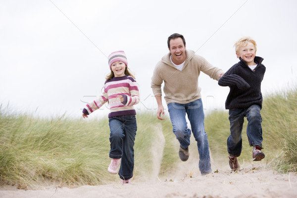 Pai dois jovem crianças corrida praia Foto stock © monkey_business
