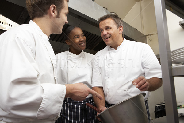 Chef Instructing Trainees In Restaurant Kitchen Stock photo © monkey_business