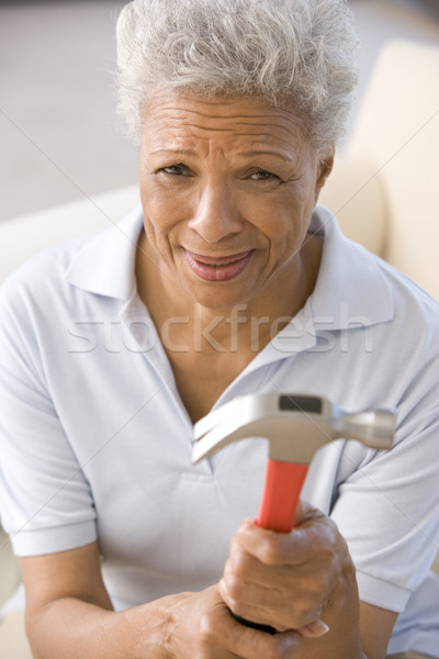 Woman holding hammer looking unsure Stock photo © monkey_business