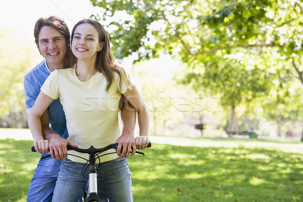 Stock photo: Couple on a bike outdoors smiling