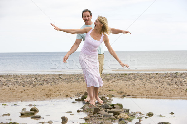 Stockfoto: Paar · strand · lopen · stenen · glimlachend · vrouw