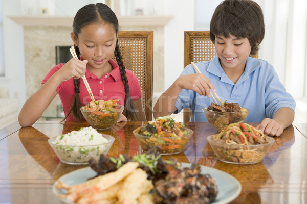 Stock photo: Two young children eating chinese food in dining room smiling