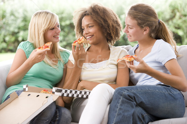 Nastolatki posiedzenia kanapie jedzenie pizza wraz Zdjęcia stock © monkey_business