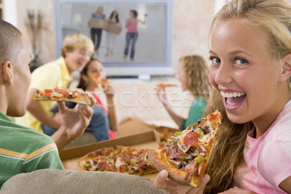 Adolescenti agatat afara televiziune mananca pizza Imagine de stoc © monkey_business
