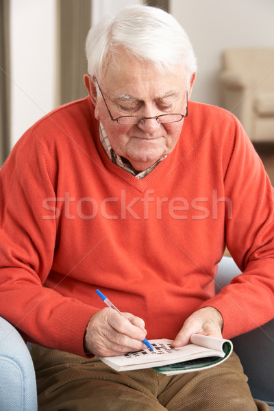 Senior Man Relaxing In Chair At Home Completing Crossword Stock photo © monkey_business