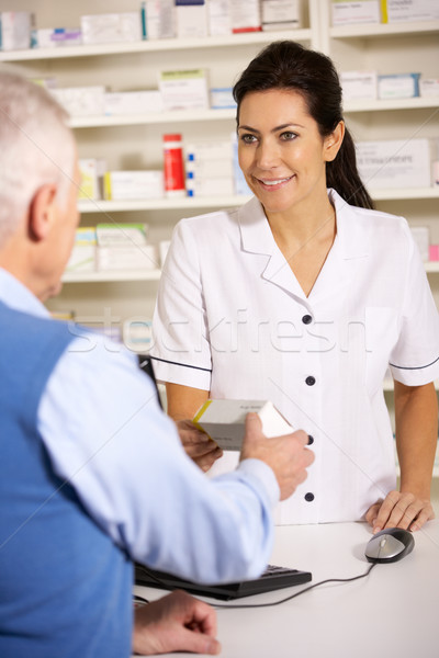 American pharmacist dispensing to senior man Stock photo © monkey_business