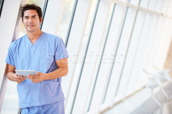 Stock photo: Doctor Using Digital Tablet In Corridor Of Modern Hospital