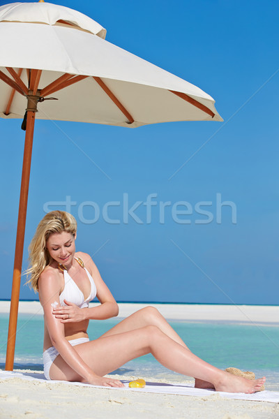 Woman Applying Sun Lotion On Beach Holiday Stock photo © monkey_business