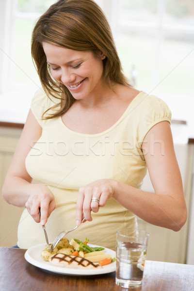 [[stock_photo]]: Femme · enceinte · cuisine · manger · poulet · légumes · souriant