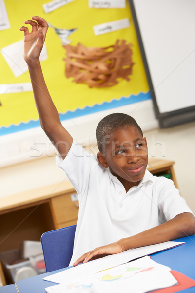 Schoolboy Raising Hand In Classroom Stock photo © monkey_business