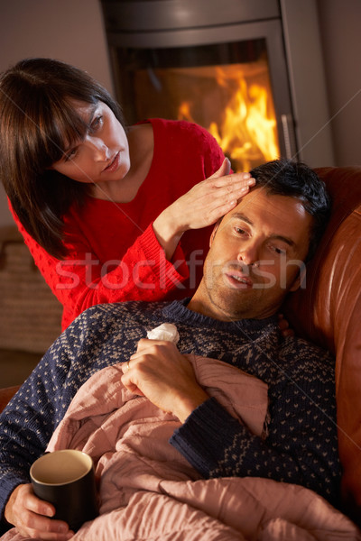 Wife Nursing Sick Husband With Cold Resting On Sofa By Cosy Log  Stock photo © monkey_business