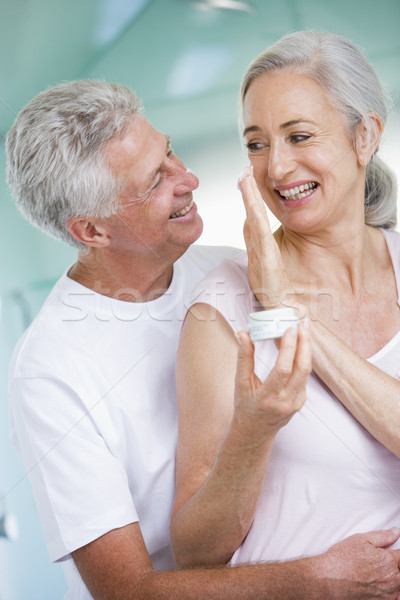 Couple embracing at a spa holding cream and smiling Stock photo © monkey_business