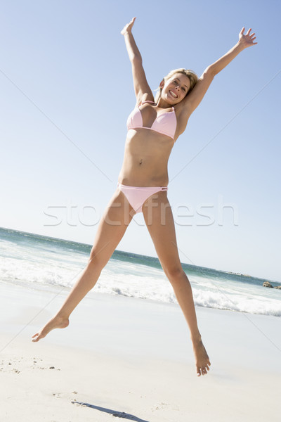 Foto stock: Mulher · jovem · saltando · praia · biquíni · mulher