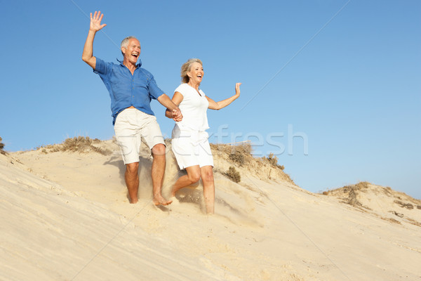 Couple de personnes âgées vacances à la plage courir vers le bas dune Photo stock © monkey_business