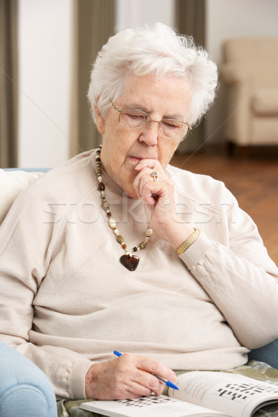 Stock photo: Senior Woman Relaxing In Chair At Home Completing Crossword