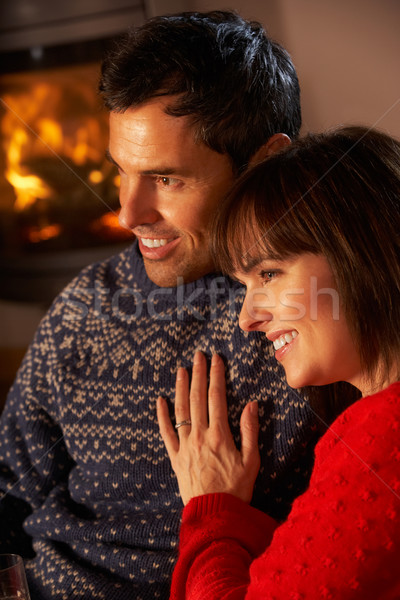 Stock photo: Middle Aged Couple Sitting Sofa Watching TV By Cosy Log Fire