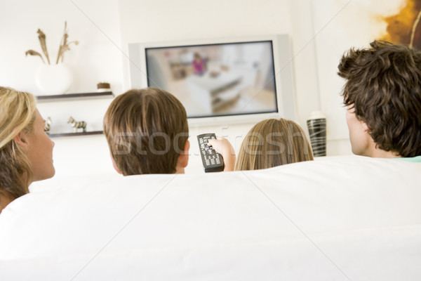 Stock photo: Family in living room with remote control and flat screen televi