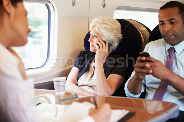 Сток-фото: деловая · женщина · мобильного · телефона · занят · пригородные · поезд · человека