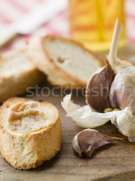 Stock photo: Cloves of Roasted Garlic spread on Toasted baguette