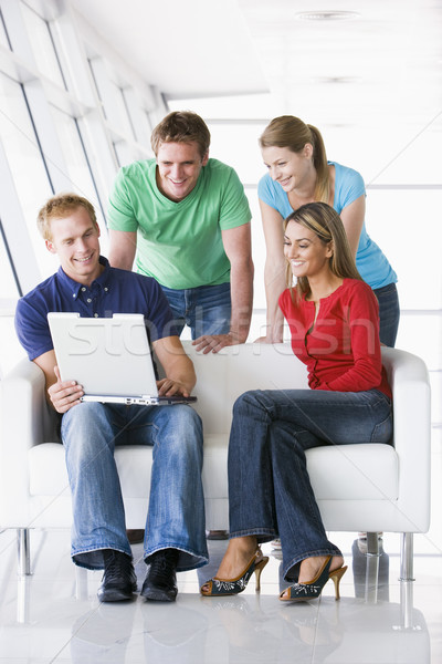 Four people in lobby looking at laptop smiling Stock photo © monkey_business