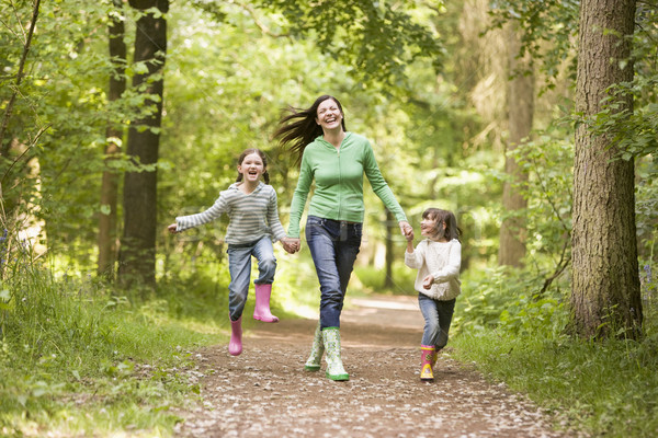 Mother and daughters skipping on path smiling Stock photo © monkey_business