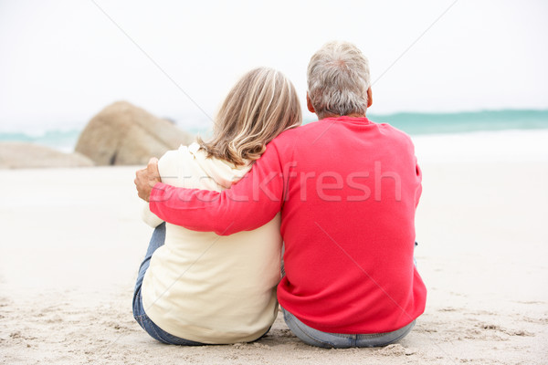 Senior Couple On Holiday Sitting On Winter Beach Stock photo © monkey_business