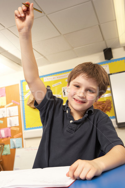 Schoolboy Answering Question In Classroom Stock photo © monkey_business