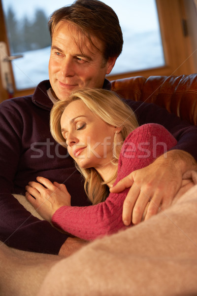 Middle Aged Couple Relaxing On Sofa In Chalet With Winter View Stock photo © monkey_business