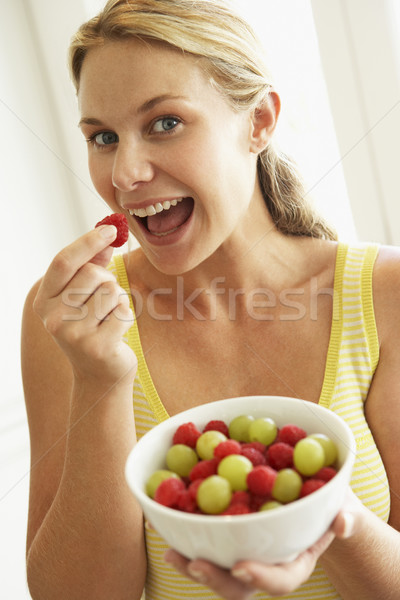 Stock photo: Young Woman Eating A Bowl Of Fruit