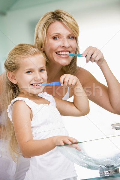 Woman and young girl in bathroom brushing teeth Stock photo © monkey_business