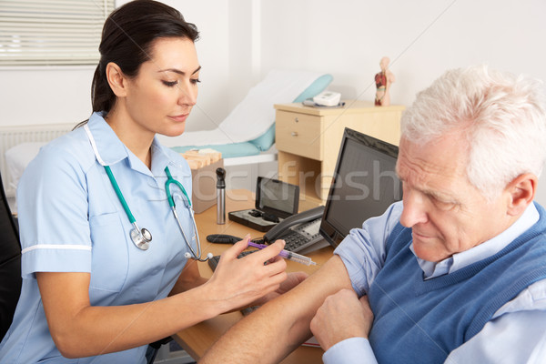 British nurse giving injection to senior man Stock photo © monkey_business