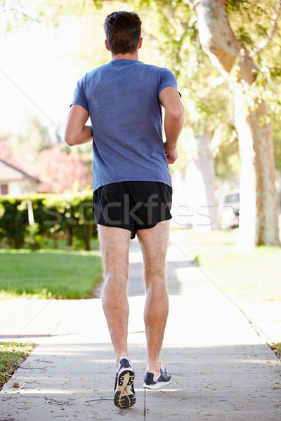 Vista posteriore maschio runner suburbana strada Foto d'archivio © monkey_business