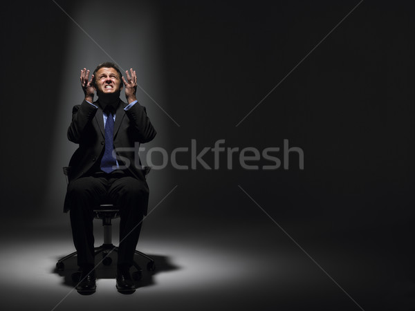 Biznesmen posiedzenia Spotlight biuro człowiek świetle Zdjęcia stock © monkey_business