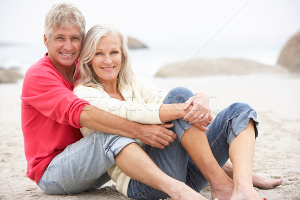 Senior Couple On Holiday Sitting On Winter Beach Stock photo © monkey_business