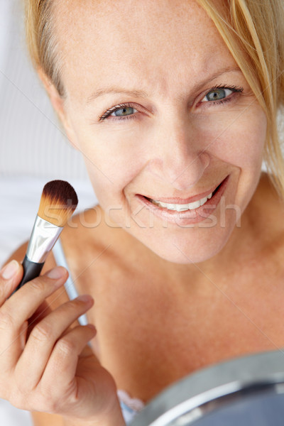 Mid age woman putting on make-up Stock photo © monkey_business