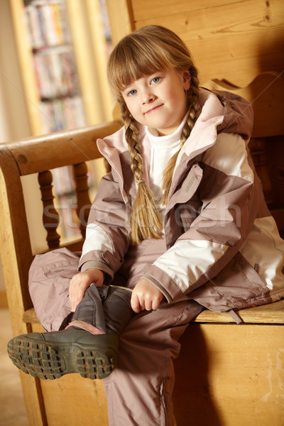 Young Girl Sitting On Wooden Seat Putting On Warm Outdoor Clothe Stock photo © monkey_business