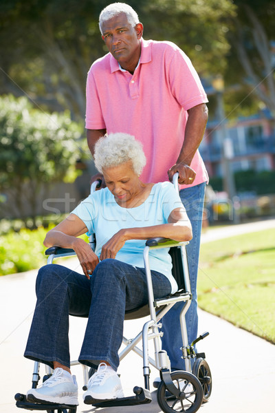 Stock photo: Senior Woman Pushing Unhappy Husband In Wheelchair