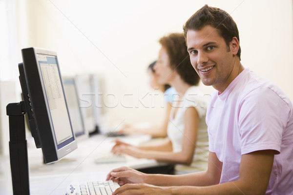 три человека сидят компьютерный зал набрав улыбаясь человека Сток-фото © monkey_business