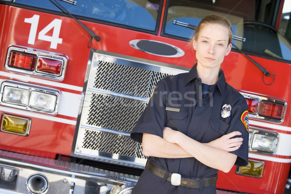 Stock photo: Portrait of a firefighter by a fire engine