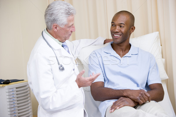 Stock photo: Doctor giving smiling man checkup in exam room