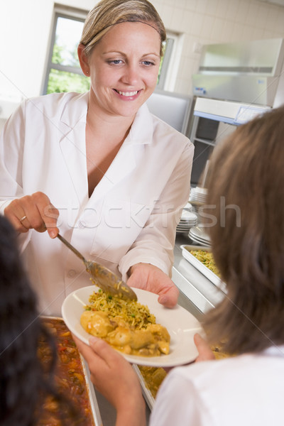 Lunchlady serving plate of lunch in school cafeteria Stock photo © monkey_business