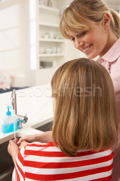 Mother And Daughter Washing Hands At Kitchen Sink Stock photo © monkey_business