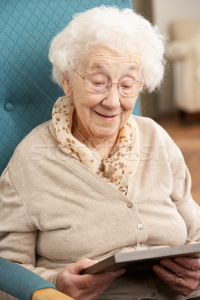 Stock photo: Senior Woman Looking At Photograph In Frame