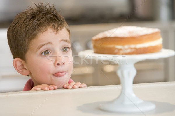 Young boy in kitchen looking at cake on counter Stock photo © monkey_business