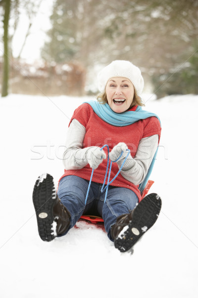 Senior Woman Sledging Through Snowy Woodland Stock photo © monkey_business