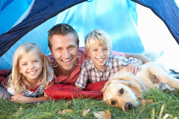 Stock photo: Young father poses with children in tent