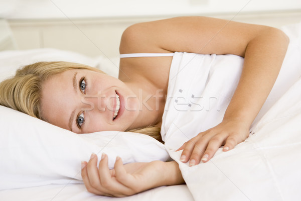 Stock photo: Woman lying in bed smiling