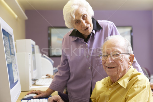 Stock photo: Senior woman helping senior man use computer