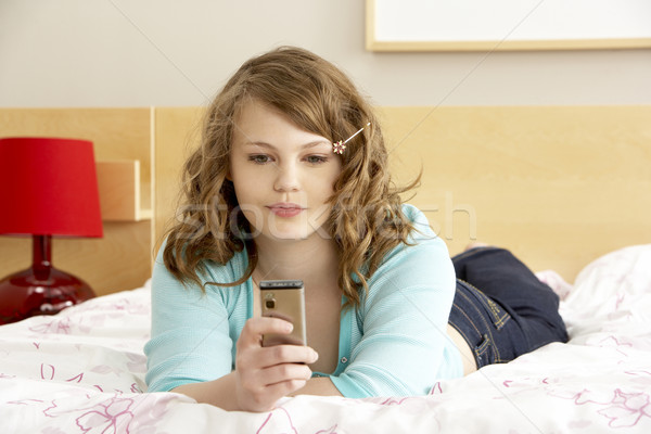 Tienermeisje slaapkamer mobiele telefoon gezicht telefoon triest Stockfoto © monkey_business