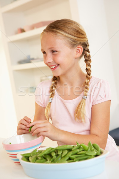 Happy girl splitting peas in kitchen Stock photo © monkey_business